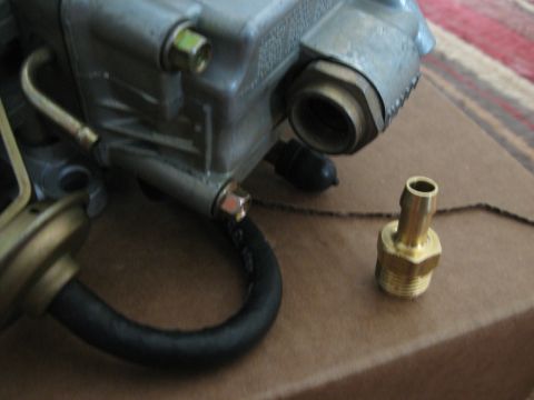 1981 Ford Bronco - Close-up of a carburetor part with a brass fitting and a black hose attached, alongside a separate brass fitting.