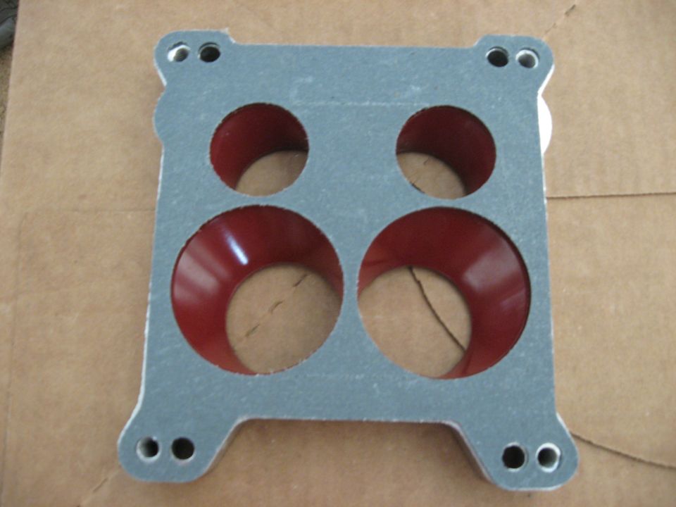 carburetor gasket with four openings, red interior, and mounting holes