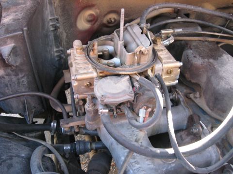 1981 Ford Bronco - Close-up view of an engine's carburetor, highlighting its mechanical components and associated plumbing.
