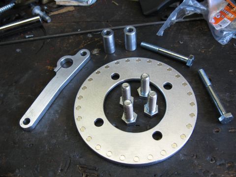 1994 Ford Bronco - Assorted metal parts and hardware laid out on a workbench surface.