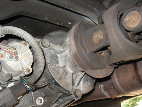 1994 Ford Bronco - Close-up view of a vehicle's drivetrain components, including a driveshaft and exhaust system.