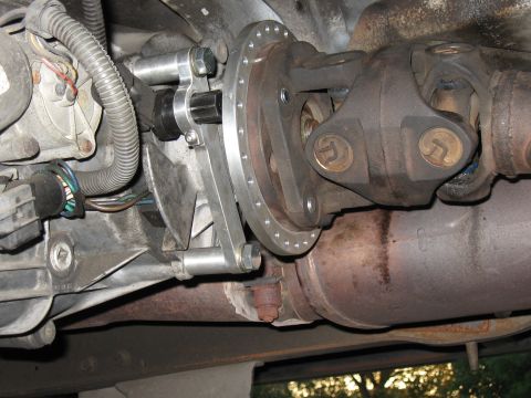 1994 Ford Bronco - Close-up view of a custom adapter plate installed on a vehicle's driveshaft assembly.