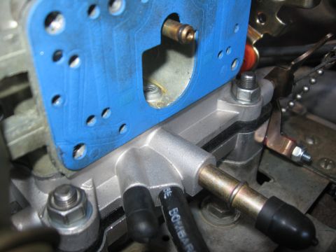 1981 Ford Bronco - Close-up view of a Holley carburetor part, a blue gasket and various metal components.