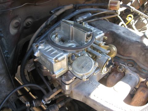 1981 Ford Bronco - A detailed view of the engine's carburetor and associated fuel lines.