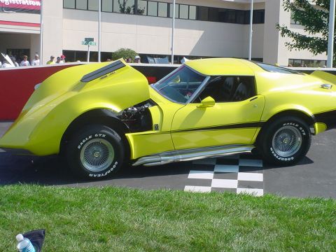 1976 Chevrolet Corvette - This yellow Chevrolet Corvette, likely a 1975 model, is displayed with its hood open, revealing the engine compartment.