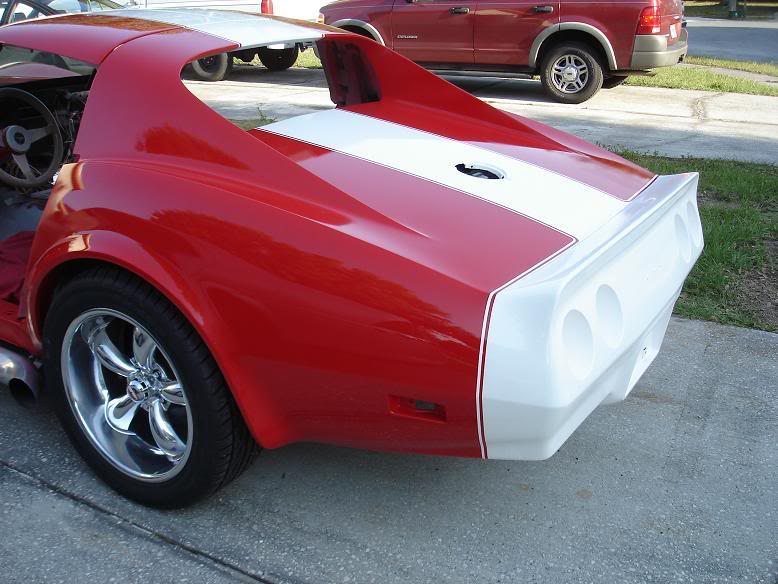 Red and white 1976 Chevrolet Corvette rear quarter panel with racing stripes and spoiler