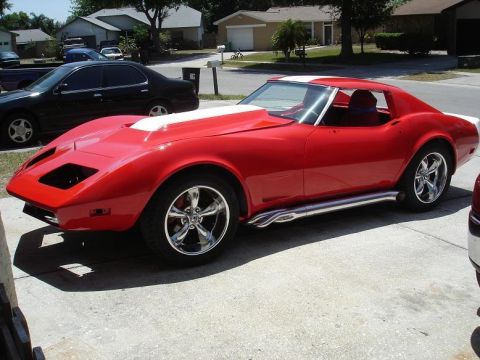1976 Chevrolet Corvette - This red Chevrolet Corvette features a white stripe on the hood and custom wheels.