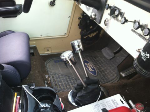 1976 Ford Bronco - Custom piston shift knobs are installed in this vehicle, which also features a Ford-branded floor mat.