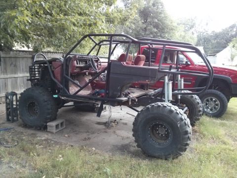 1986 Ford Bronco - This heavily modified vehicle, likely from the 1980s, has a custom roll cage and oversized tires.