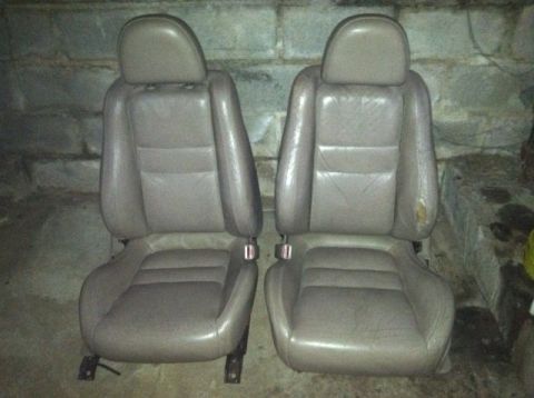 1997 Ford Probe - Two tan leather car seats are shown, likely for a coupe, with visible wear on the right seat's bolster.