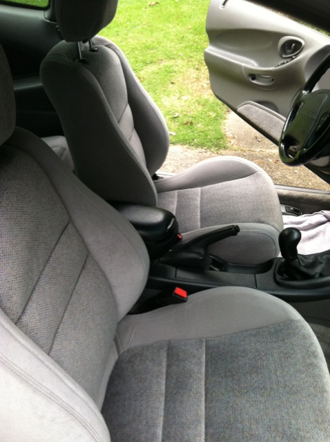 1997 Ford Probe - Interior view of a car's front seats and dashboard area, with the driver's door open.