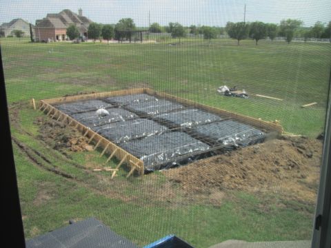 1995 Ford Bronco - A foundation is being prepared for construction on a large grassy area with houses in the background.