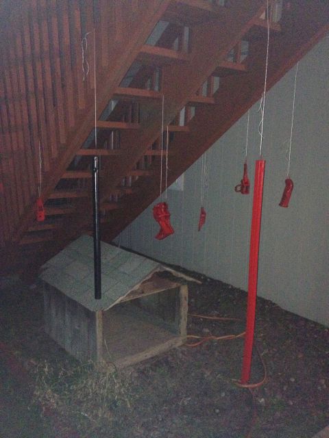 2005 Jeep Wrangler - Various red painted parts are suspended by strings, possibly for drying or display, near a wooden structure.