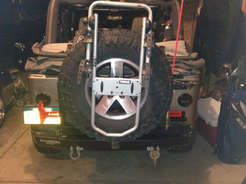 2005 Jeep Wrangler - This Jeep Wrangler features a Thule spare tire carrier mounted to the rear, along with a spare tire and a custom bumper.