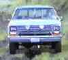 1988 Ford Bronco - This white Ford pickup truck is shown from a straight-on front view, with a blurred background.
