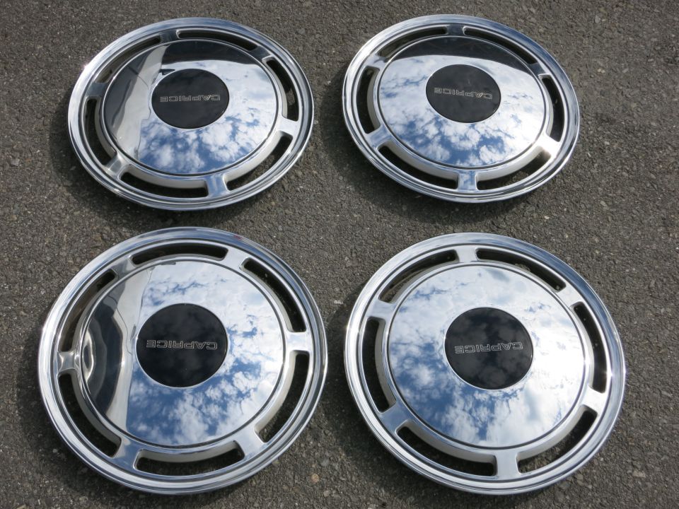 Four chrome hubcaps with black centers, each labeled 'CAPRICE'