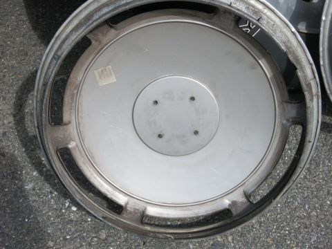 1991 Ford LTD Crown Victoria - A single hubcap is shown, resting on asphalt. Another hubcap is partially visible to the right.