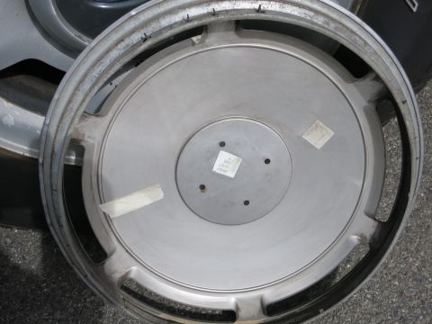 1991 Ford LTD Crown Victoria - A single silver hubcap is shown, with visible tape and stickers on its surface.