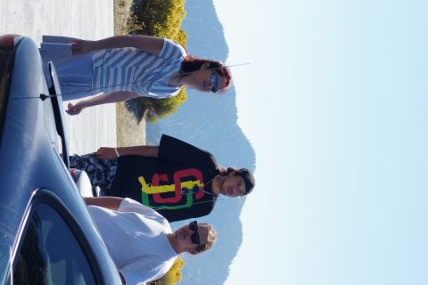1995 Ford Taurus - A group of friends gather near a car on a sunny day with mountains visible in the distance.
