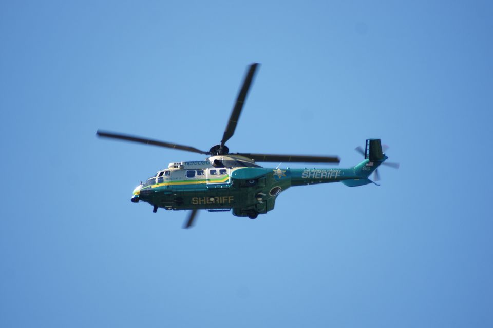 Green and white sheriff helicopter in flight