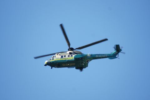 1995 Ford Taurus - A sheriff's department helicopter is seen flying in the sky.