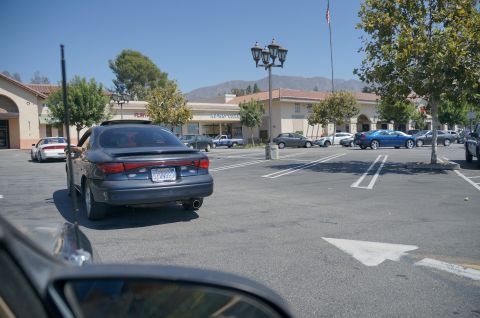 1995 Ford Taurus - A dark blue sedan is parked in a lot, showing its rear end and license plate.