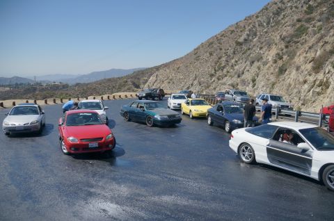 1995 Ford Taurus - A collection of vehicles are gathered on a scenic mountain pass.