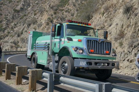 1995 Ford Taurus - A light green fire truck with "ANF WT 11" visible on its side drives along a winding road.