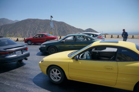 1995 Ford Taurus - Several cars are parked on a scenic overlook with mountains in the background.
