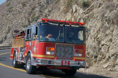 1995 Ford Taurus - A red fire truck with the number 82 on the front is driving on a road.
