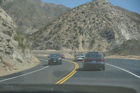 1995 Ford Taurus - Multiple vehicles travel on a highway through a mountainous landscape.