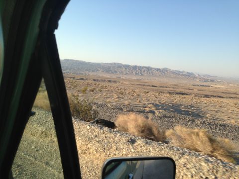 1986 Ford Bronco - Desert landscape seen from inside a vehicle, with a side mirror reflecting the view.