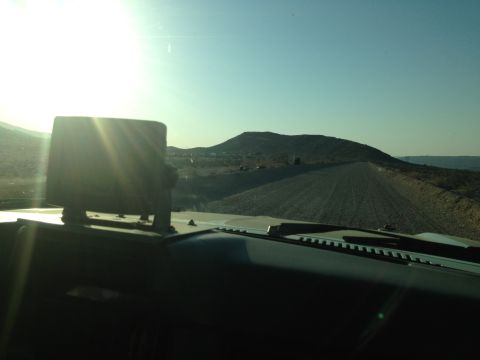 1986 Ford Bronco - Driving on a dusty road with a large object mounted on the dashboard.