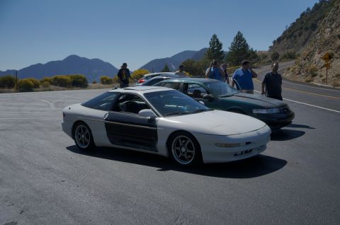 1995 Ford Taurus - Two cars parked on a roadside overlook with mountains in the background.