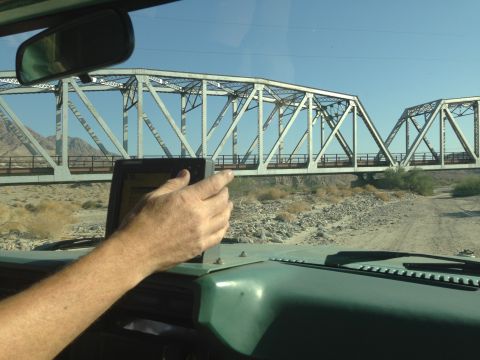 1986 Ford Bronco - Driving towards a bridge in a desert landscape, with a GPS device visible on the dashboard.