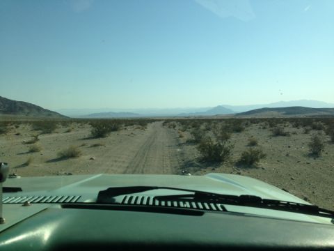 1986 Ford Bronco - Driving through a barren desert landscape under a clear blue sky.