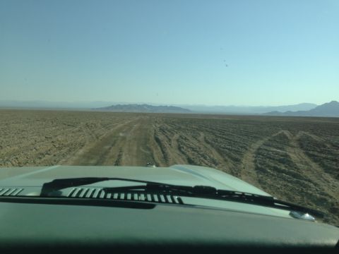 1986 Ford Bronco - Driving through a desert landscape with mountains in the distance.