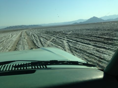 1986 Ford Bronco - Driving across a dry lake bed with many tire tracks visible.