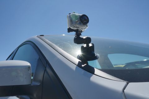 1995 Ford Taurus - An action camera is mounted to the windshield of a car, with the sun glinting off the glass.