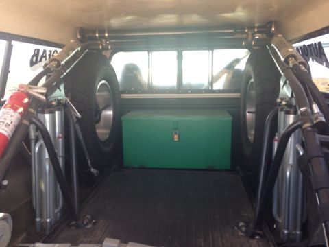 1986 Ford Bronco - The interior of a vehicle's cargo area is equipped with spare tires and safety equipment.