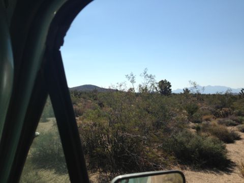 1986 Ford Bronco - View of a desert landscape from inside a vehicle, with a watermark for SUPERMOTORS.