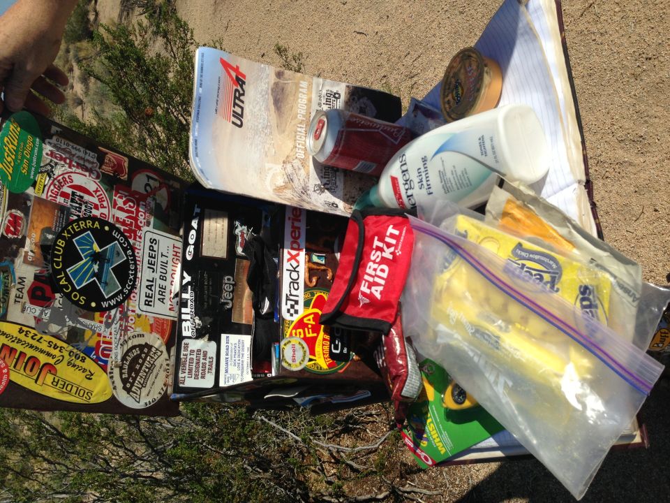 Collection of off-road stickers, a can of soda, and a first aid kit on a surface