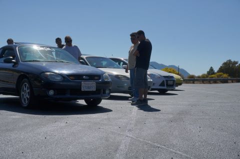 1995 Ford Taurus - Several cars are parked in a lot under a clear blue sky.