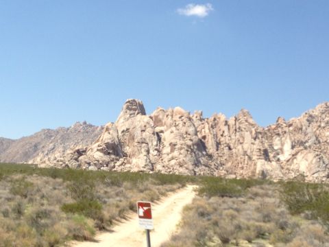 1986 Ford Bronco - Desert landscape with rock formations and a dirt road, likely a trail.