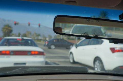 1995 Ford Taurus - A view from inside a vehicle shows multiple cars stopped at a traffic light on a sunny day.