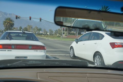1995 Ford Taurus - A white sedan is seen from behind at a traffic light, with another white car to its right.