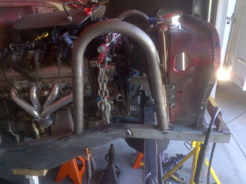 1985 Jeep CJ7 - Engine and roll cage assembly in progress on a red vehicle.