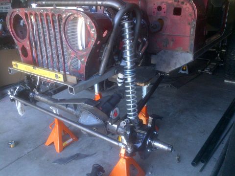1985 Jeep CJ7 - This Jeep CJ is undergoing significant modifications, with the front end disassembled and supported by jack stands.