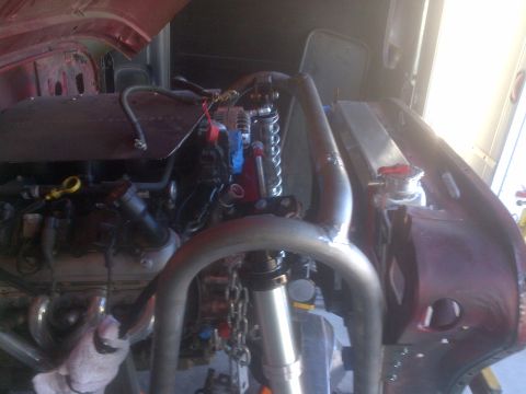 1985 Jeep CJ7 - Custom roll cage and engine components visible in the engine bay of a vehicle.