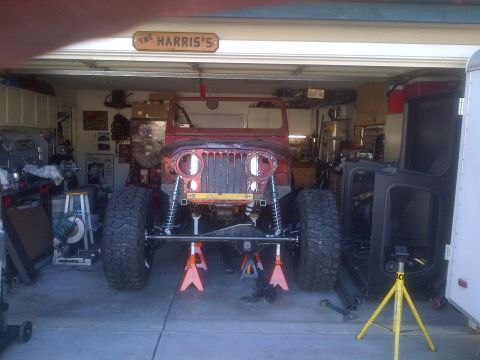 1985 Jeep CJ7 - Front view of a 1985 Jeep CJ7 undergoing repairs in a garage.
